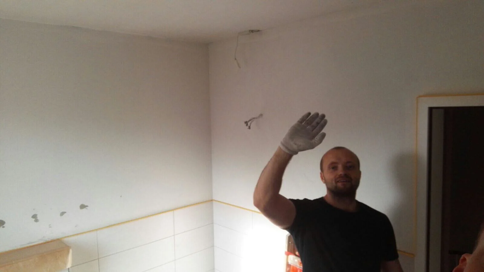 Malermeister beim Streichen einer Decke im Innenraum